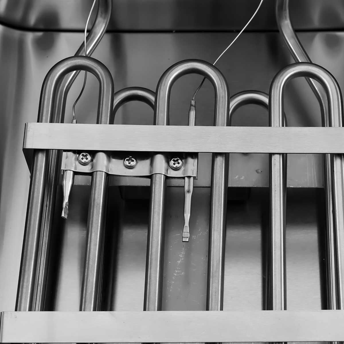 Close-up of heating elements in an appliance, secured with screws.