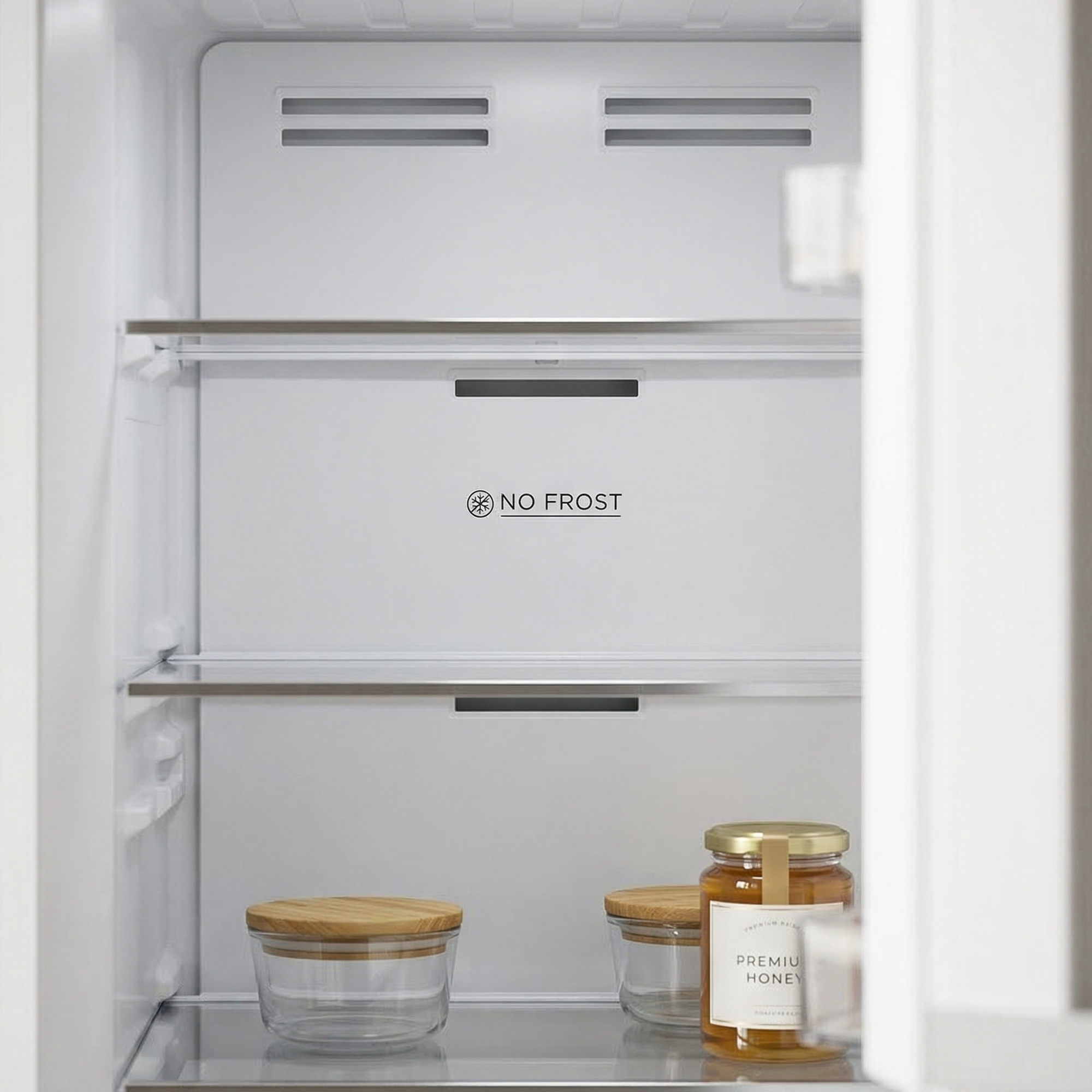 Ein offener Kühlschrank mit zwei Gläsern Honig und einem leeren Glas.