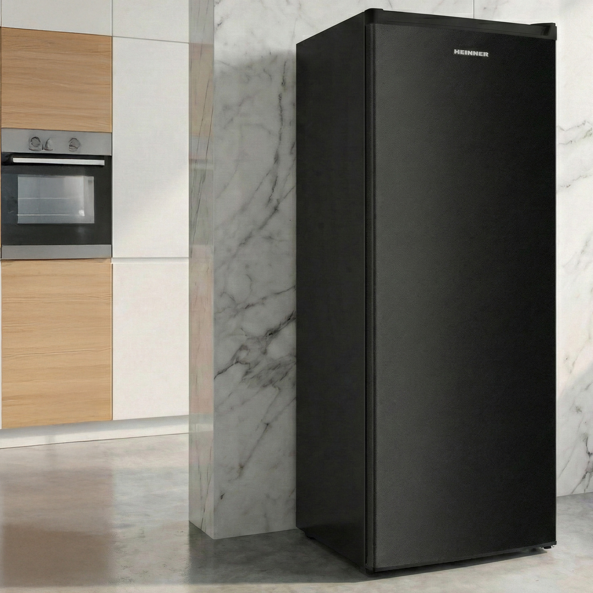 Een zwarte koelkast staat naast een marmeren pilaar in een moderne keuken.