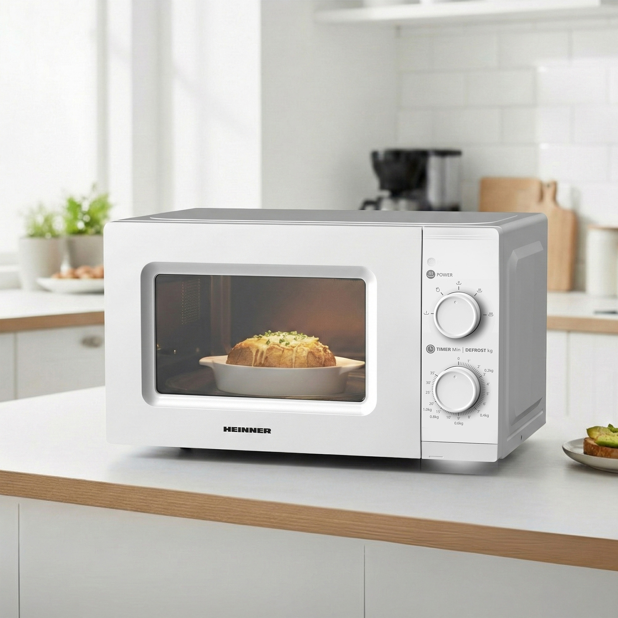 A white Heinner microwave oven with a bowl of bread inside.