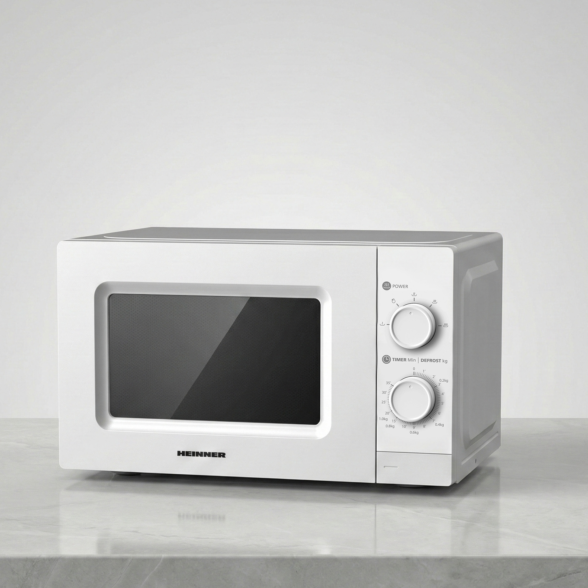 A white Heinner microwave with a black door and control knobs.