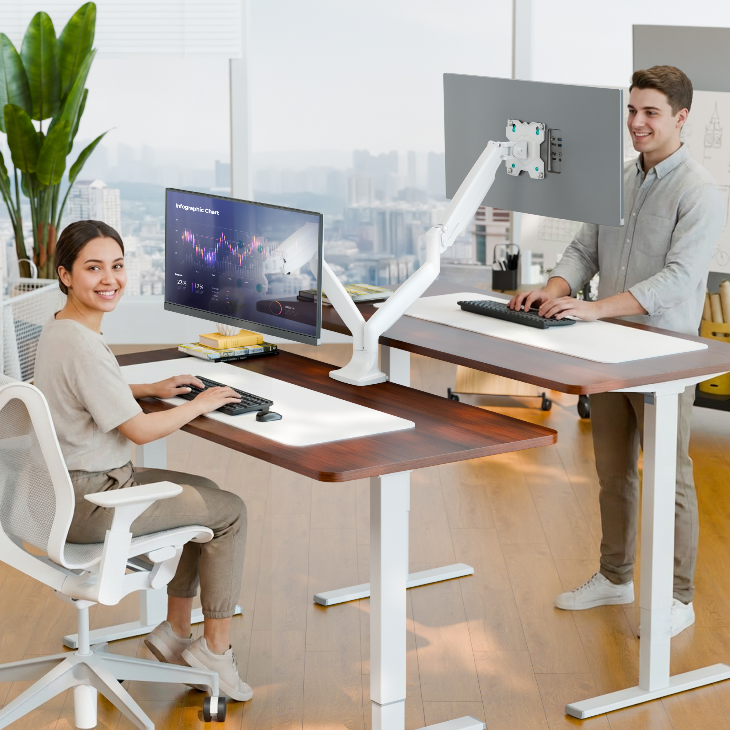 Ein Mann und eine Frau arbeiten an höhenverstellbaren Schreibtischen in einem Büro.