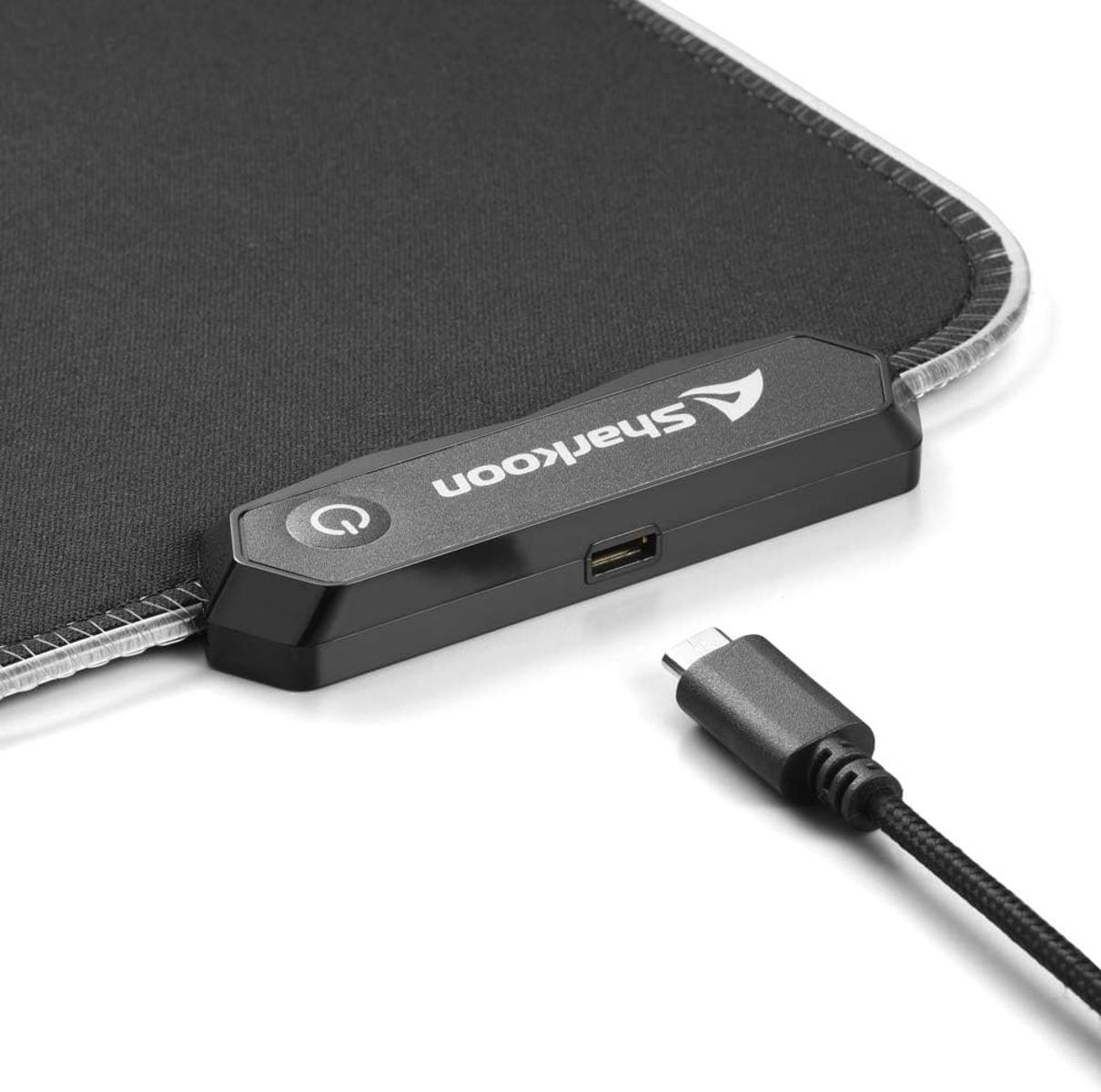 Un tapis de souris Sharkoon noir avec un câble USB-C. Un bouton d'alimentation est visible.