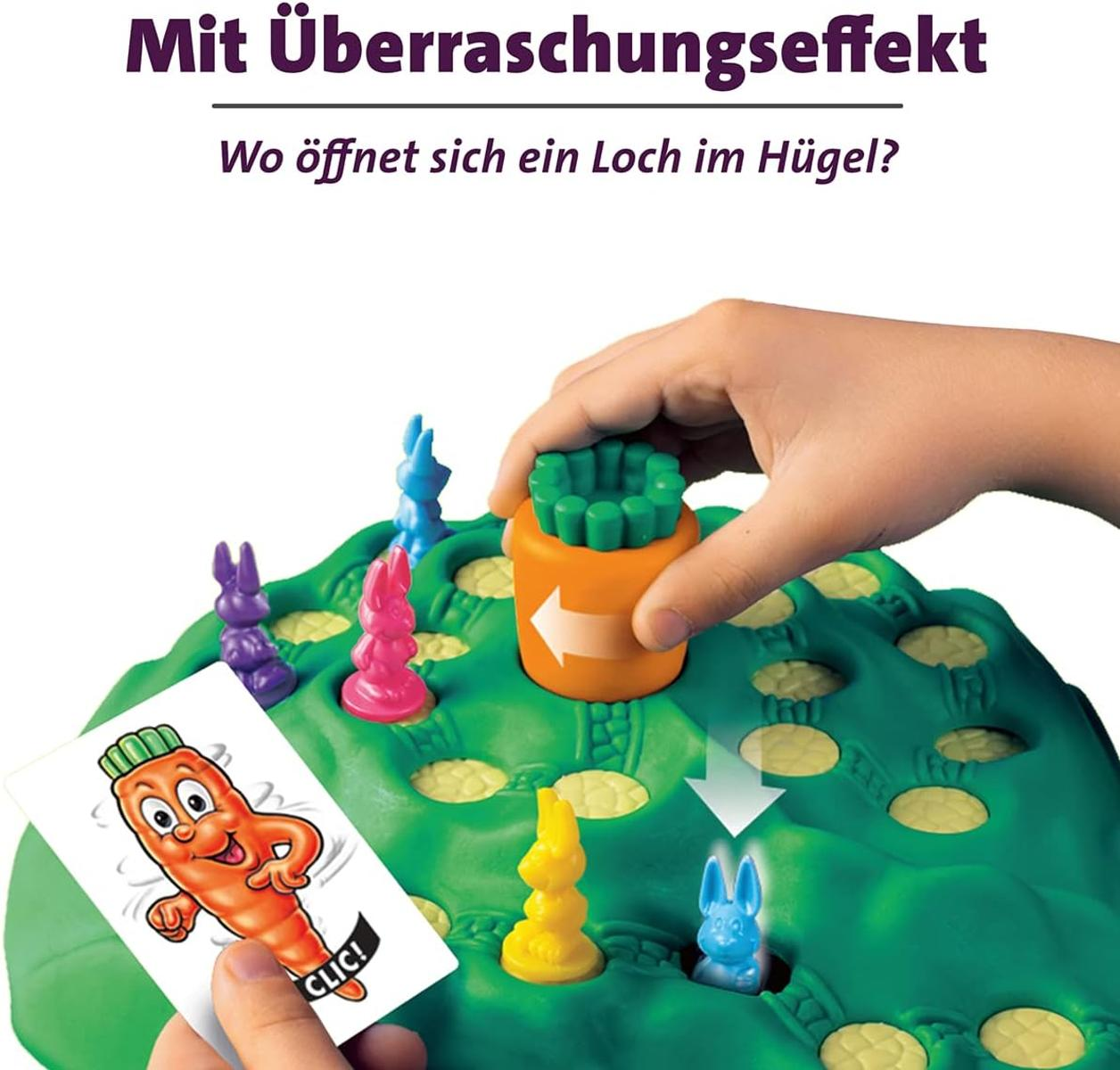 Un niño juega un juego de mesa con figuras de conejos y una ficha de zanahoria.
