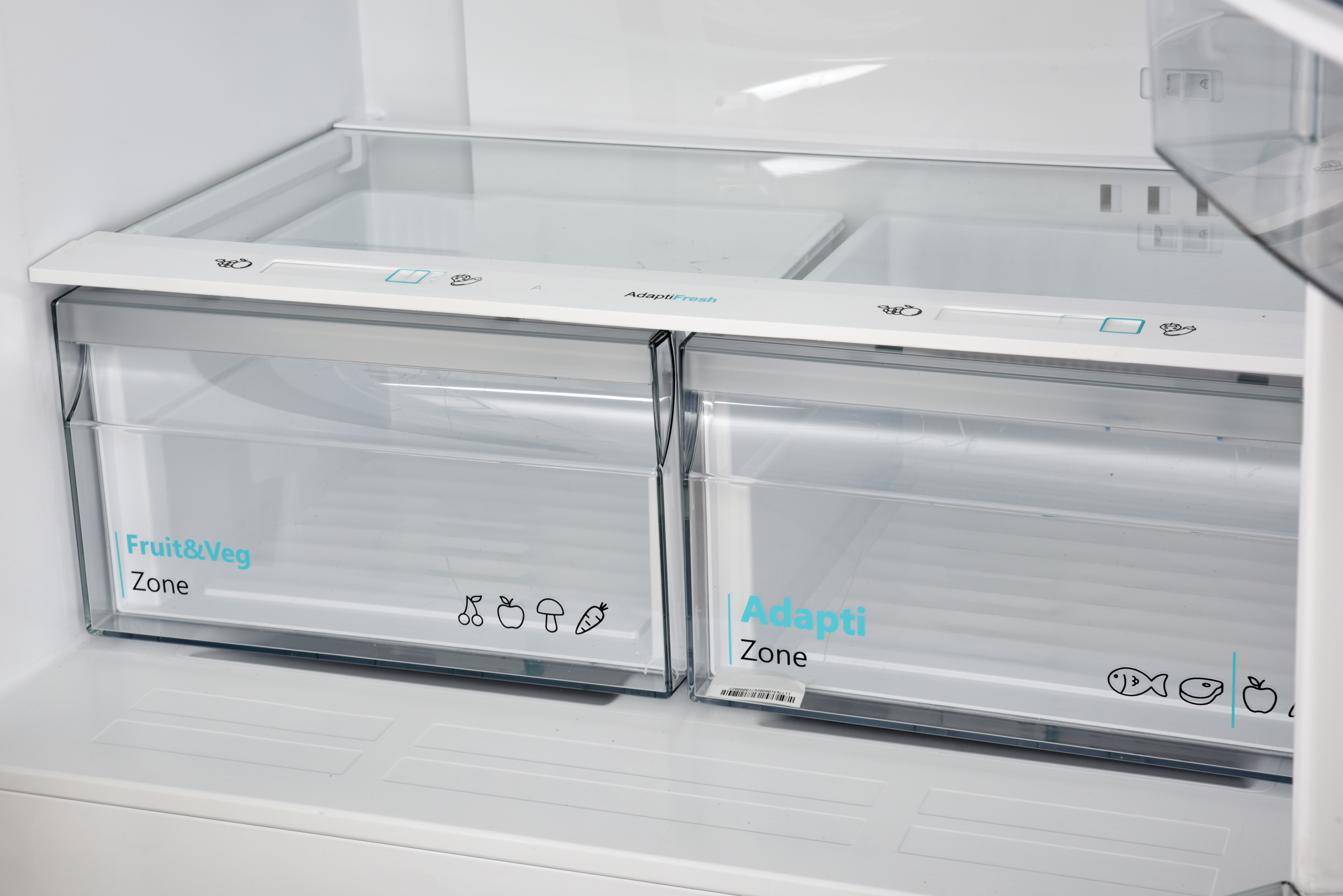 Two clear refrigerator drawers, one labeled Fruit & Veg, the other labeled Adapti Zone.