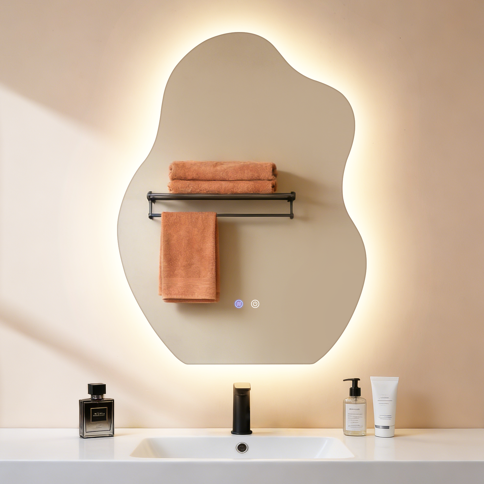 Un espejo de baño con luces, toallas naranjas colgadas.