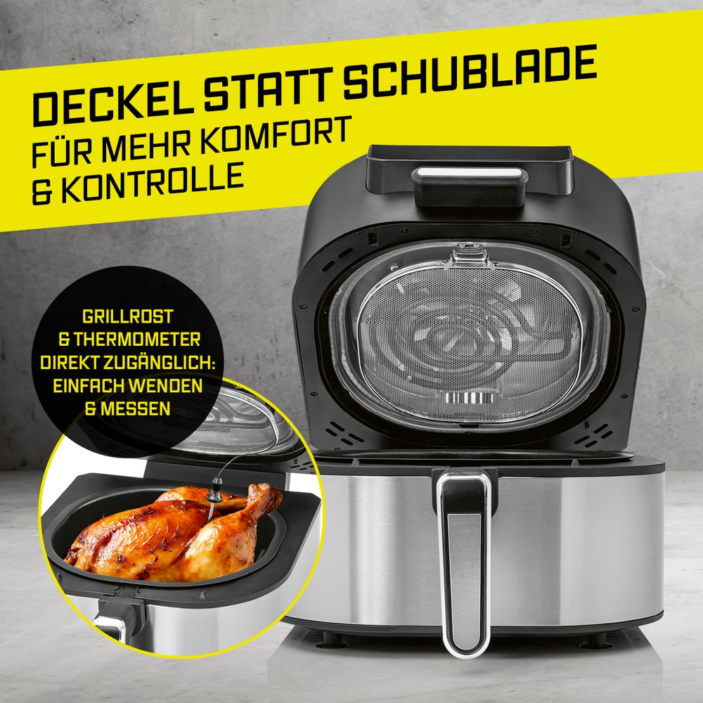 Ein silberner und schwarzer Airfryer mit offenem Deckel, der einen gebratenen Hähnchenschenkel zeigt.