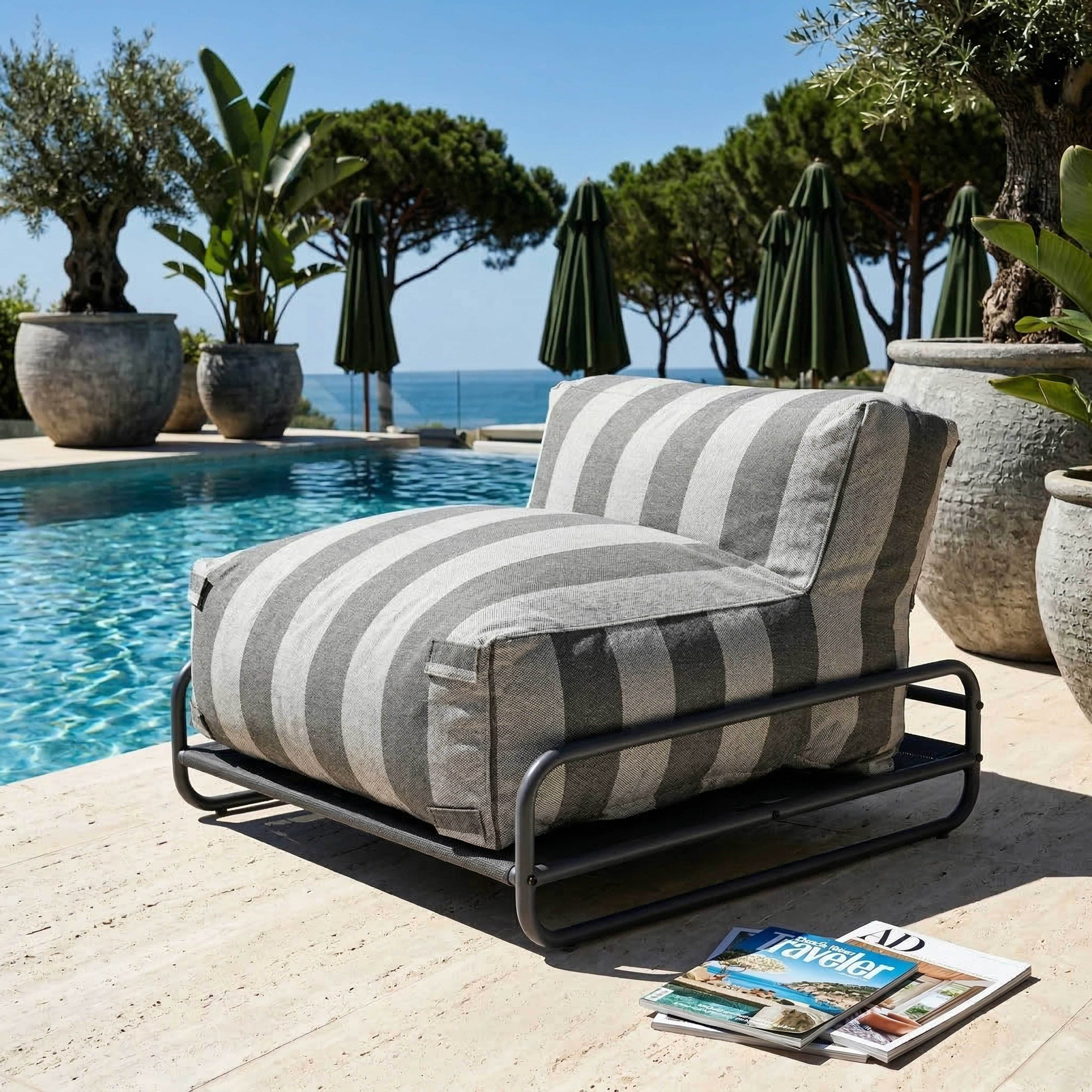 Ein gestreifter Sessel am Pool mit Büchern und Pflanzen.