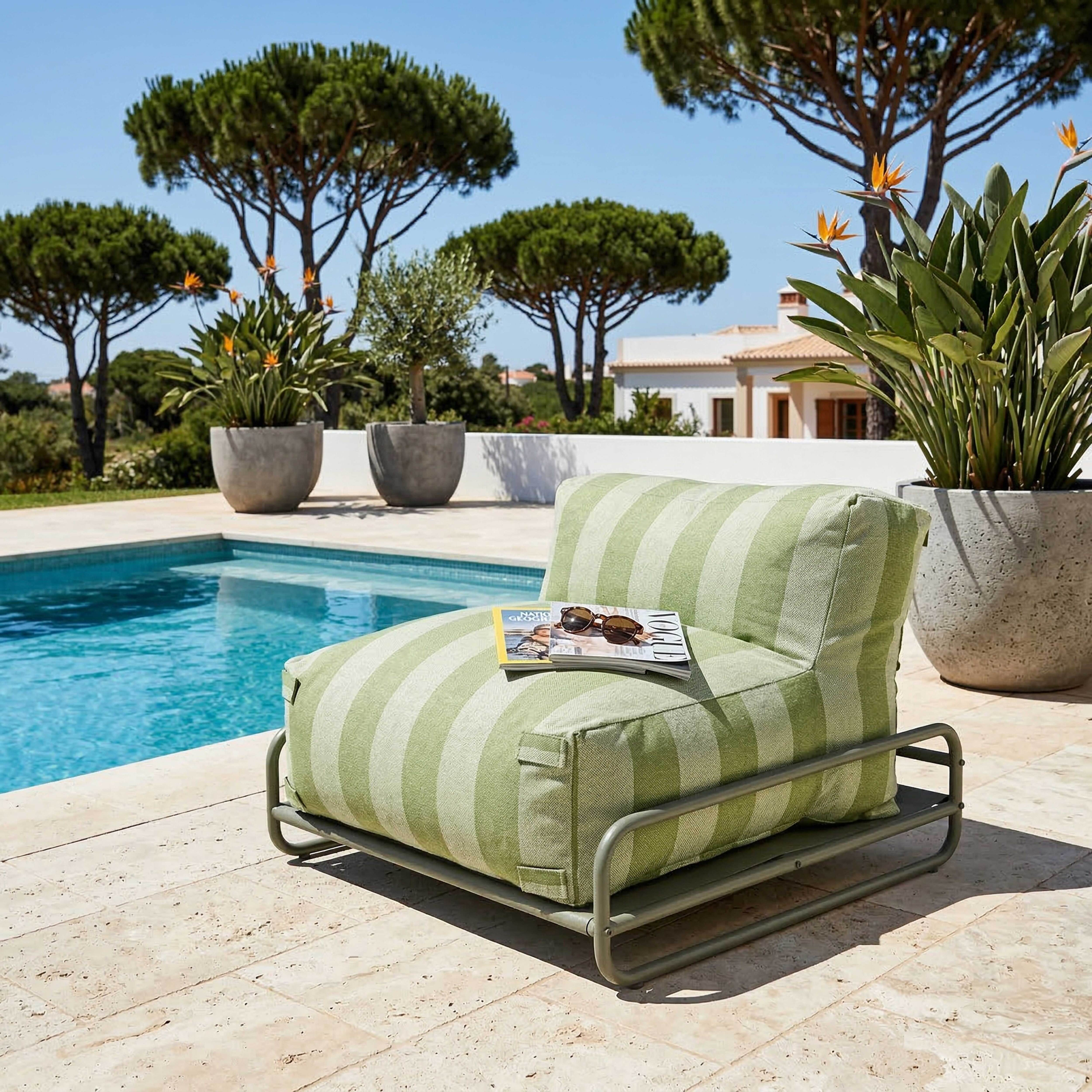 Ein gestreifter Sessel neben einem Pool, mit Pflanzen und einem Haus im Hintergrund.