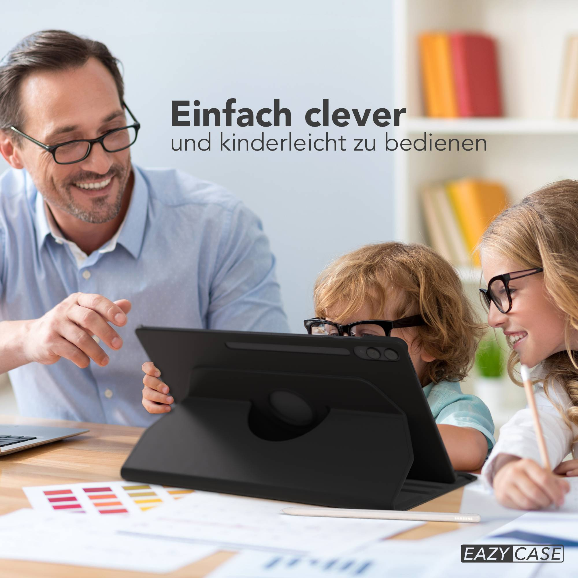 Mann zeigt Tablet Kindern. Sie sitzen am Schreibtisch mit Büchern im Regal.
