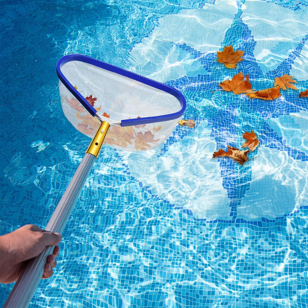 Hand hält einen blauen Laubkescher, der Blätter aus einem blauen Kachelschwimmbecken schöpft.