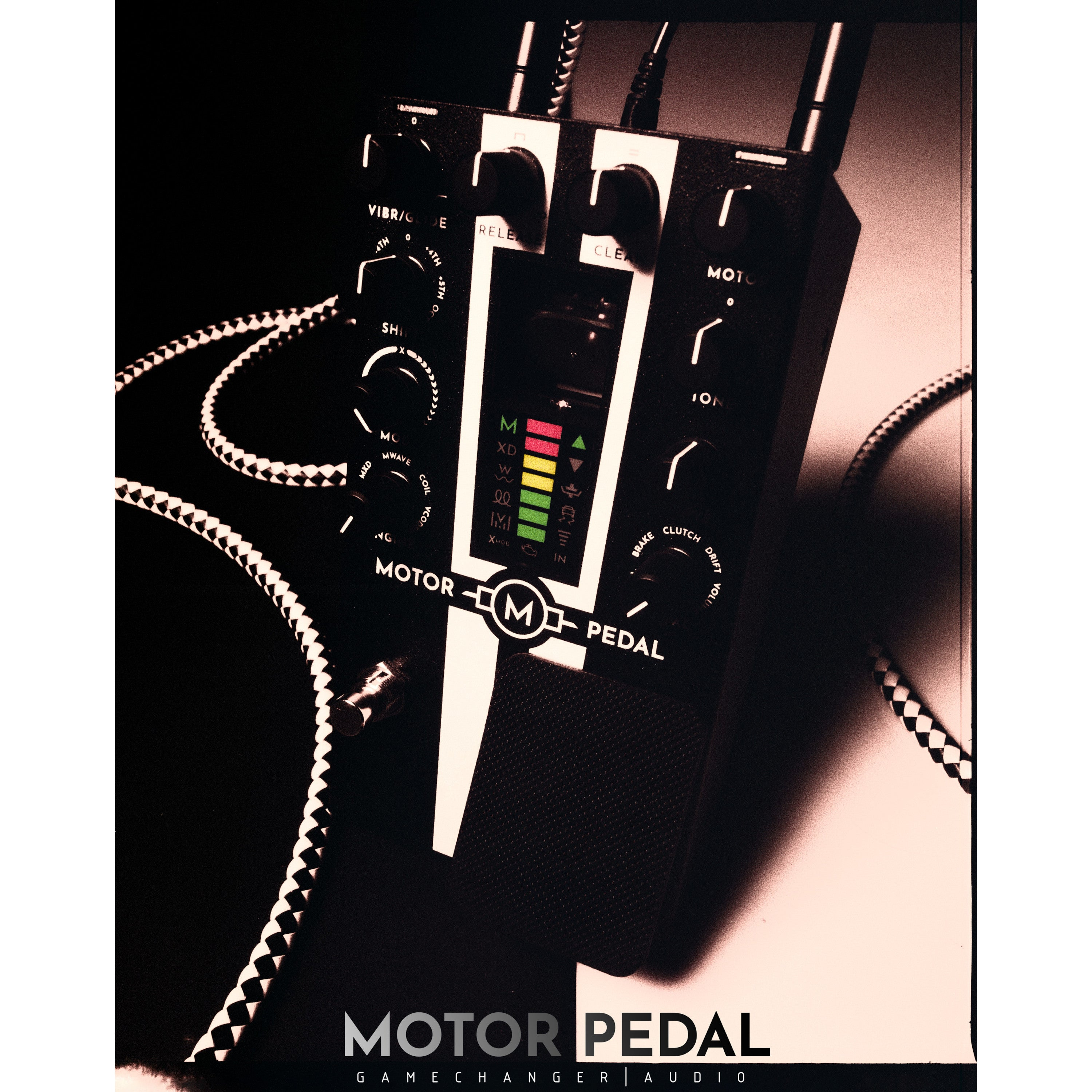 A black Motor Pedal with knobs, lights, and cables.