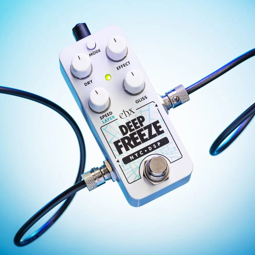 A white guitar effects pedal with four knobs and a footswitch, connected by cables.