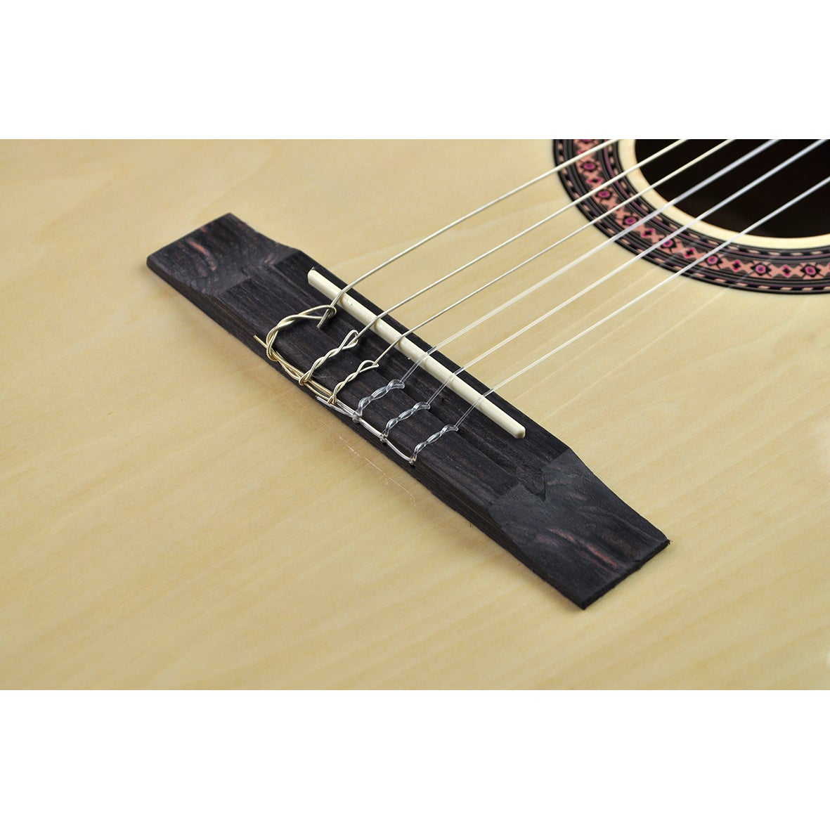 Nahaufnahme der Gitarrenbrücke mit sechs Saiten und einem Saitenhalter aus Ebenholz.