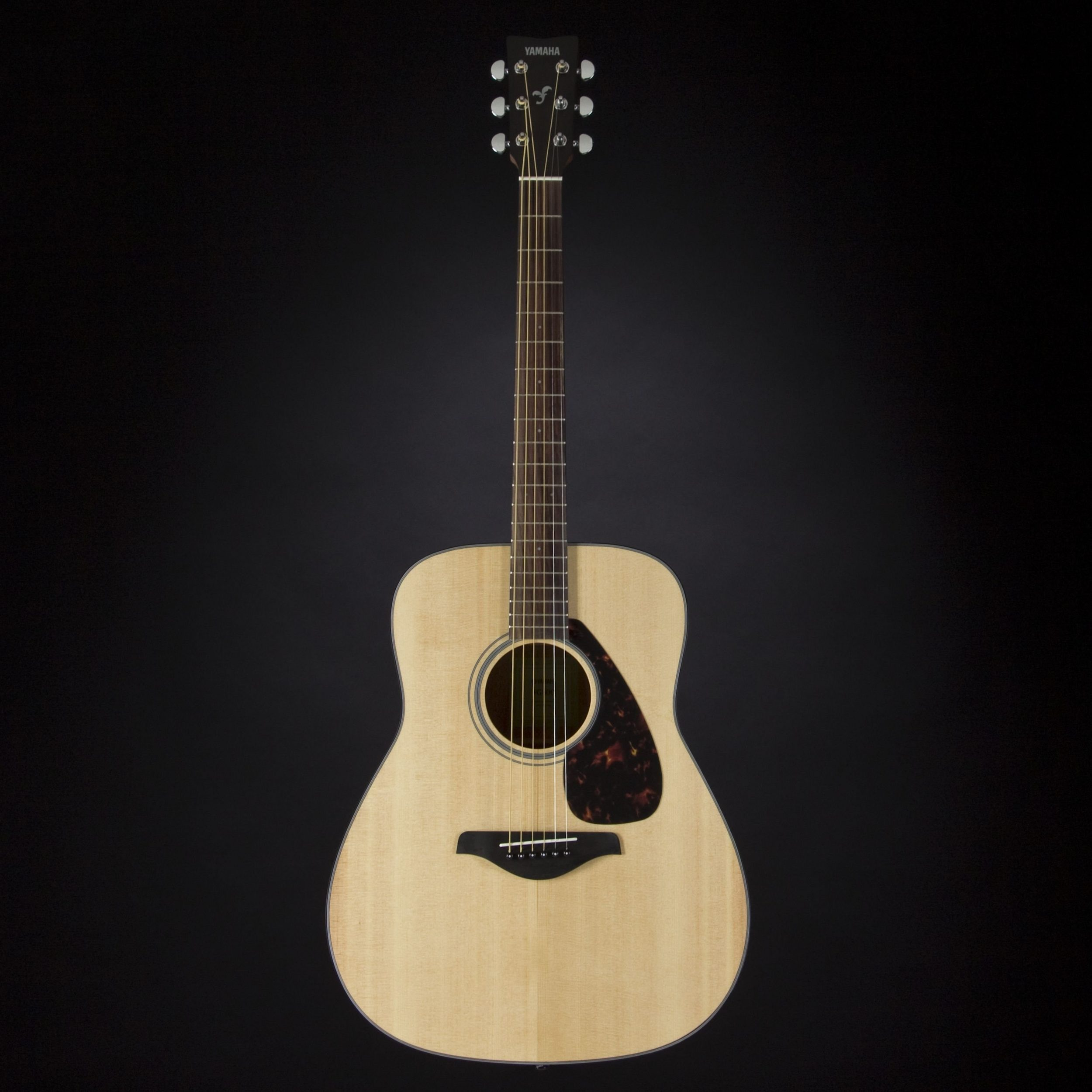 Jasna gitara akustyczna z sześcioma strunami, czarną główką i płytką ochronną w kolorze żółwia.