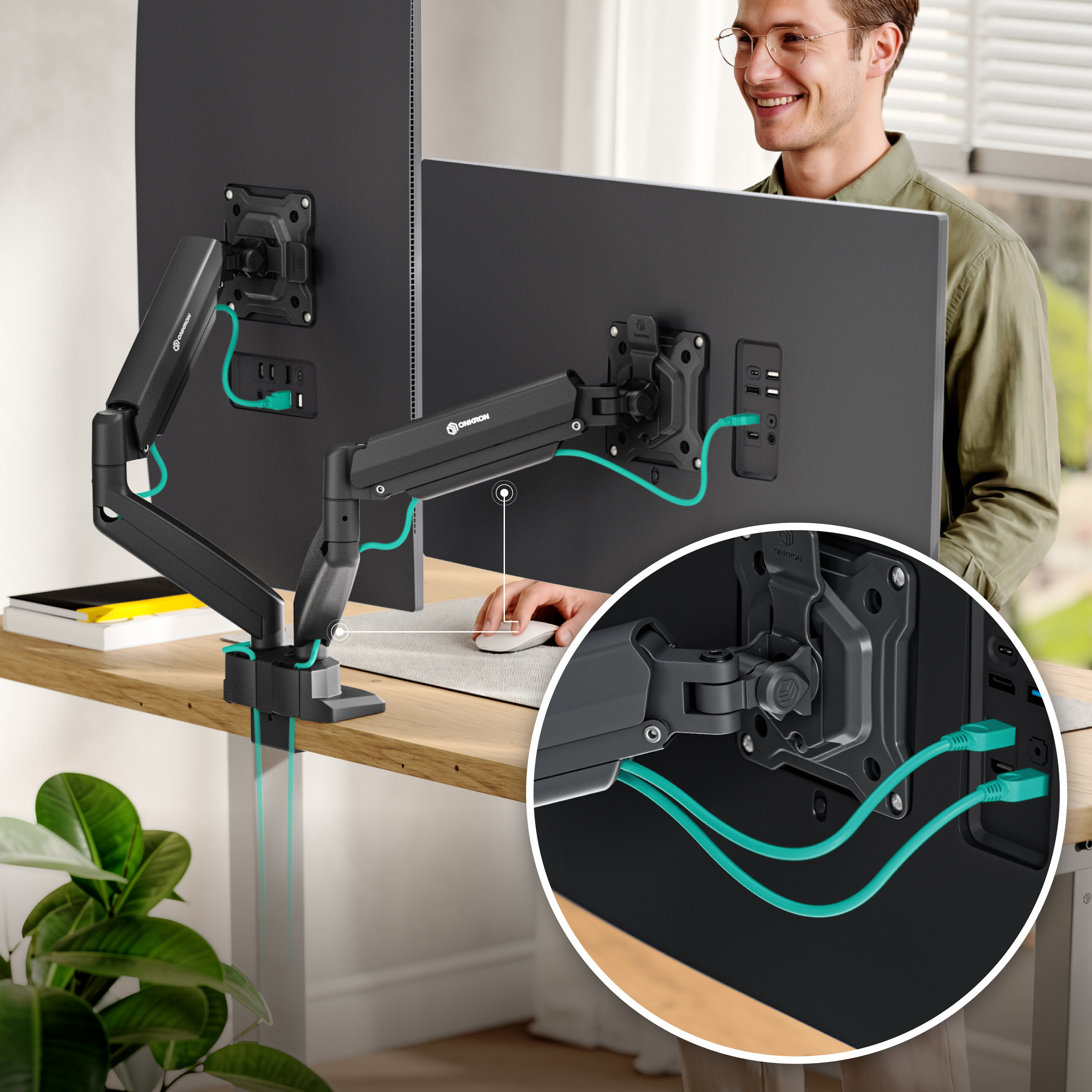 Mężczyzna uśmiecha się, siedząc przy biurku z dwoma monitorami.