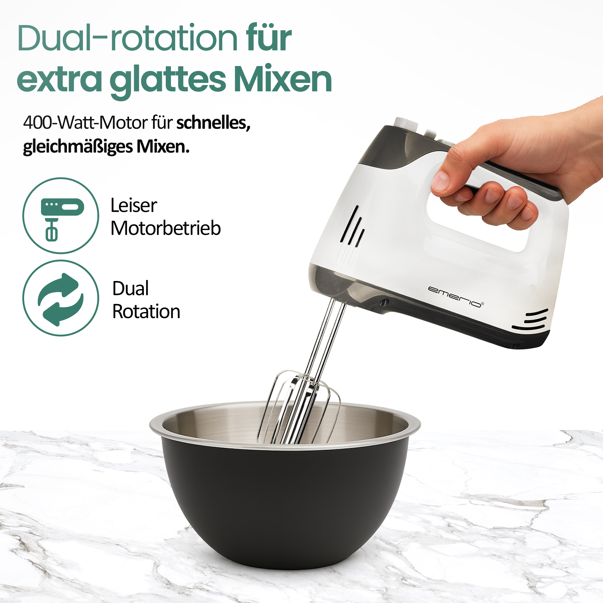 Handmixer mit Rührbesen über einer schwarzen Schüssel auf Marmor.