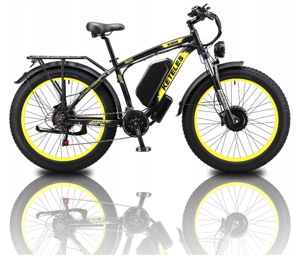 Bicicletta elettrica nera con cerchi gialli, pneumatici larghi, batteria e portapacchi.