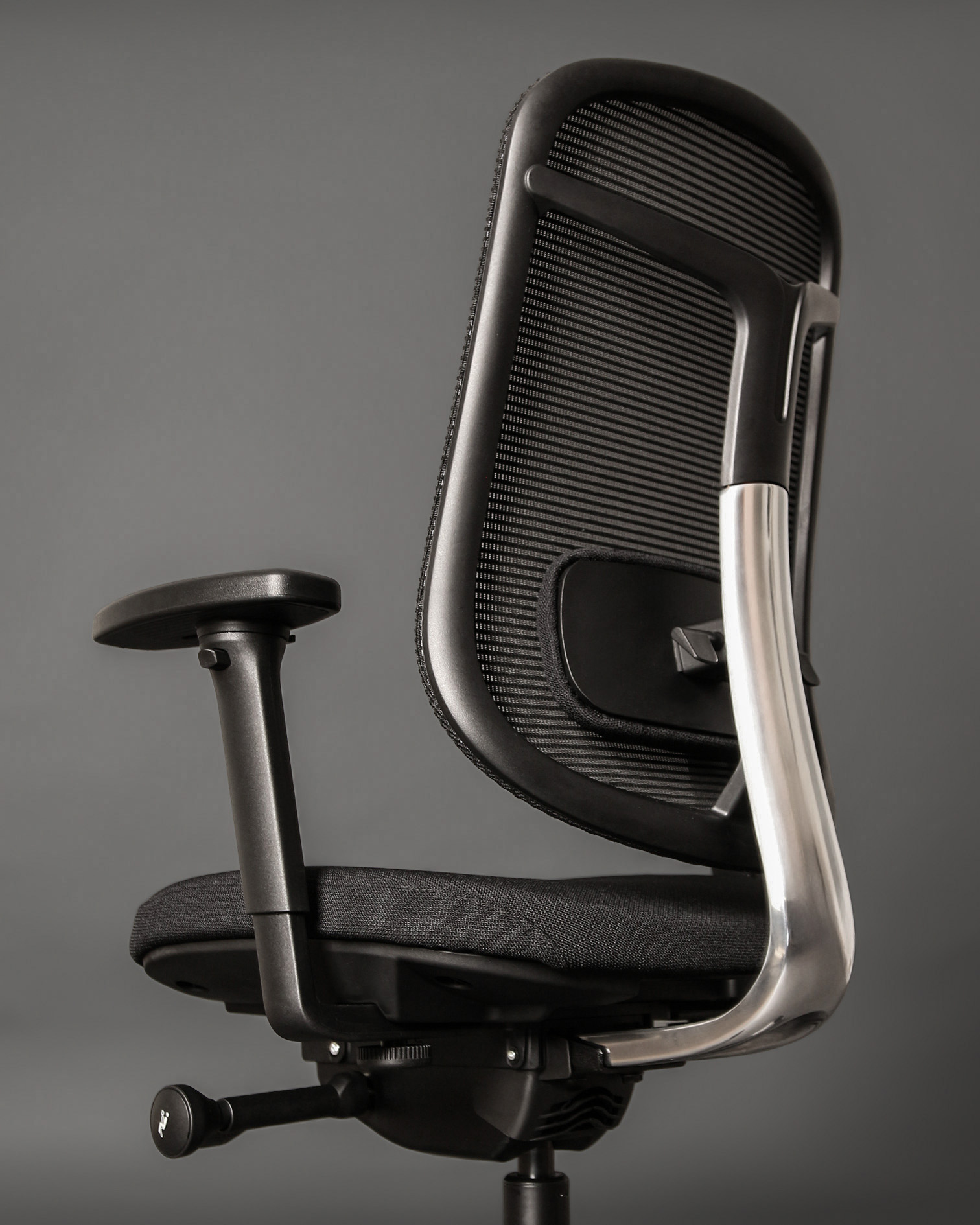 Czarny fotel biurowy z siatkowym oparciem i srebrną metalową ramą.