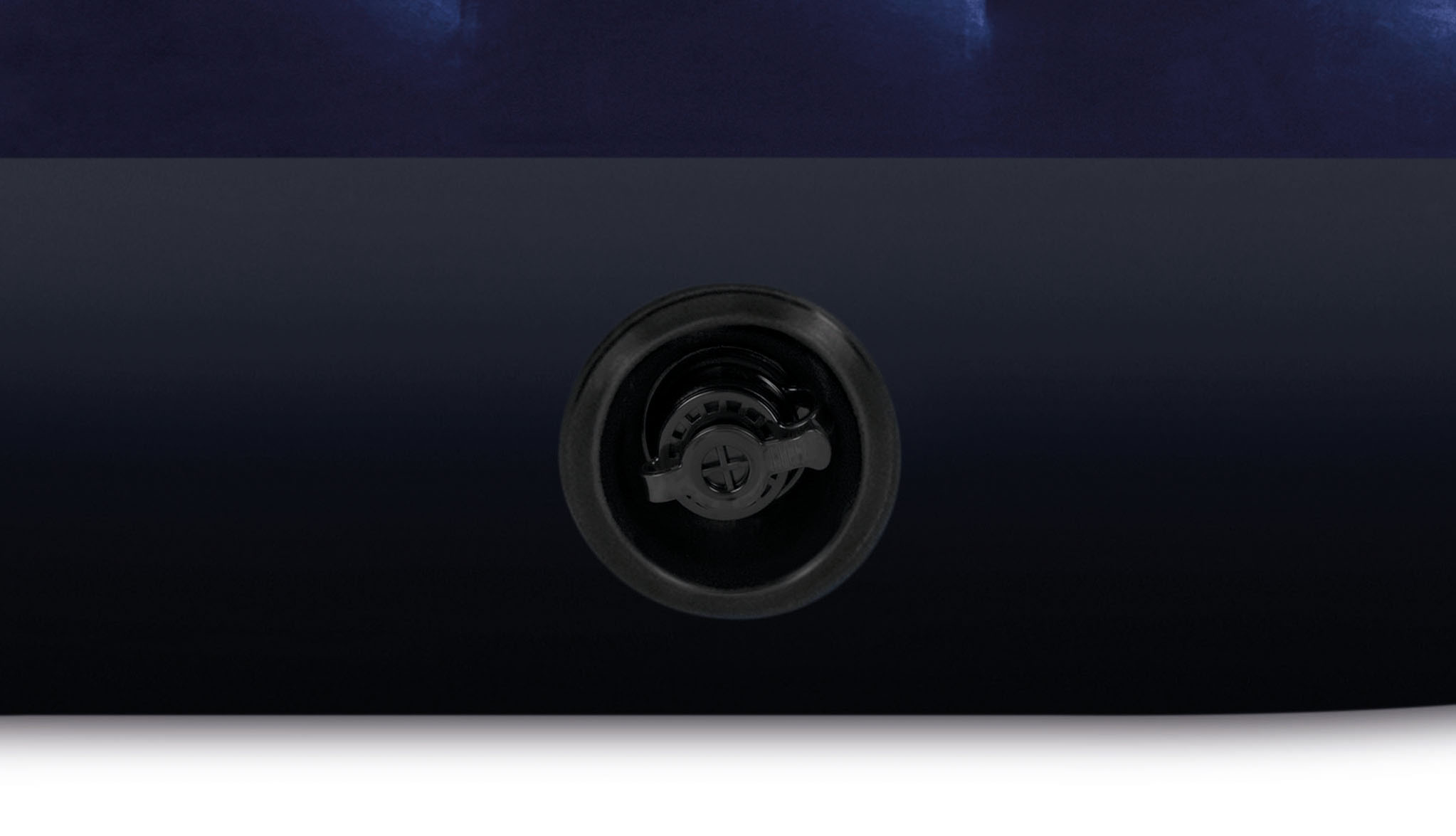 Zbliżenie czarnego zaworu z zakręcaną nakrętką na ciemnoniebieskim tle.