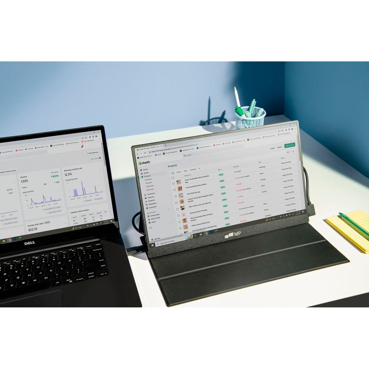 Ein Laptop und ein externer Monitor mit Shopify-Daten auf einem Schreibtisch.