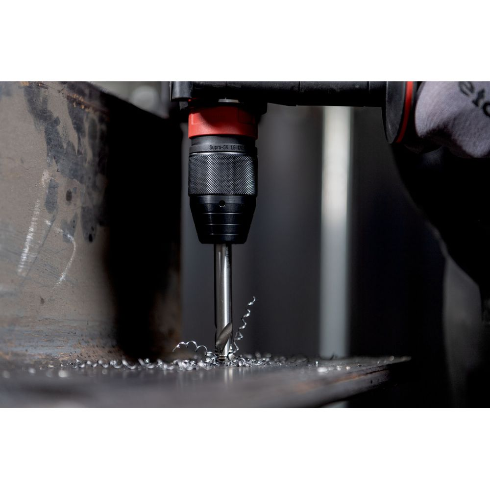 Wiertło wierci w metalu, tworząc wióry. Widok z bliska.