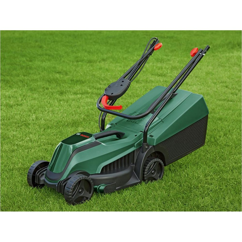 Yeşil bir Bosch çim biçme makinesi, mükemmel biçilmiş bir çim üzerinde duruyor.