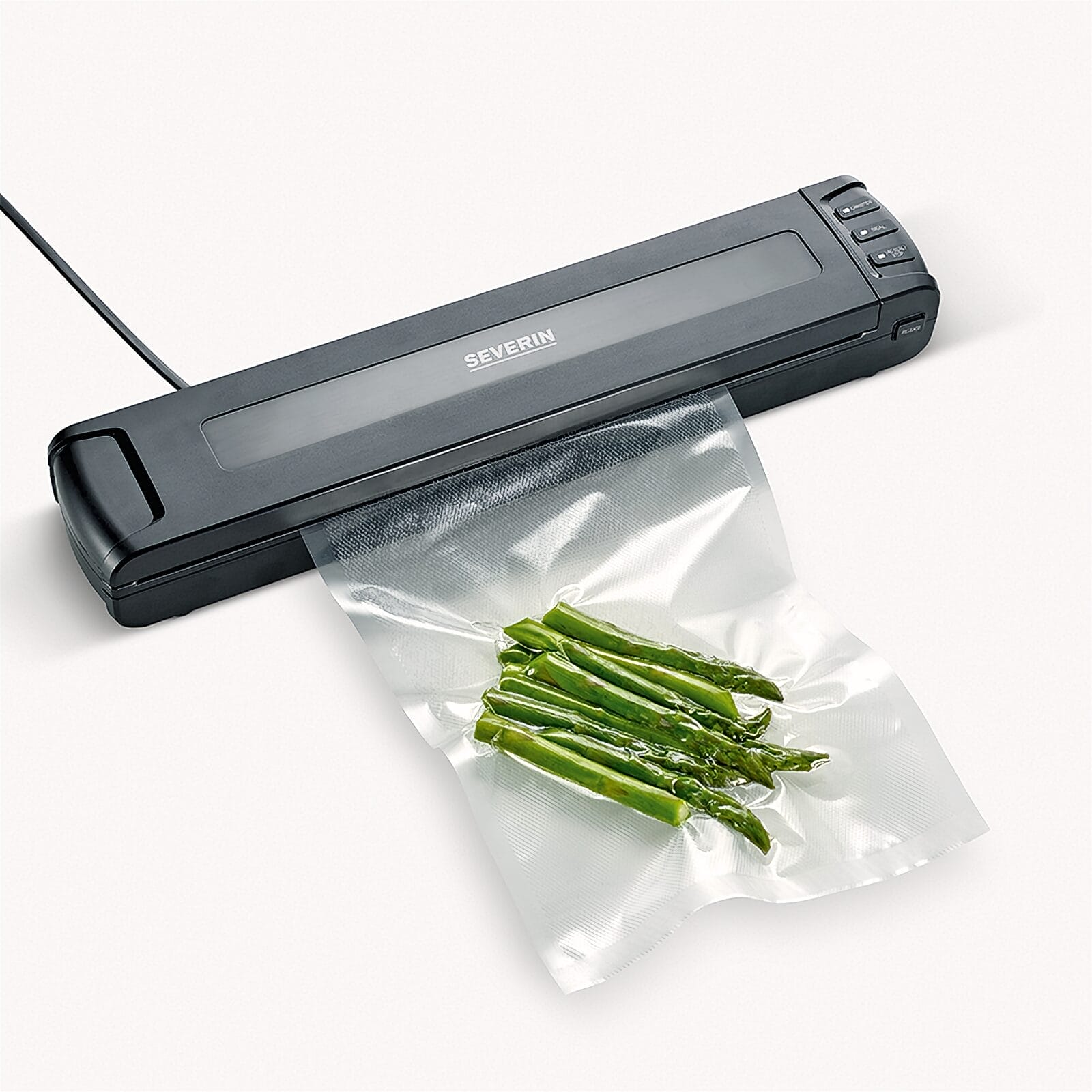 Ein Vakuumiergerät versiegelt einen Beutel mit grünem Spargel.