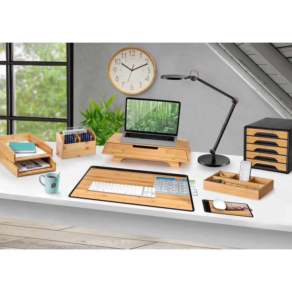 Ein Schreibtisch mit Laptop, Tastatur, Uhr und Büromaterialien.