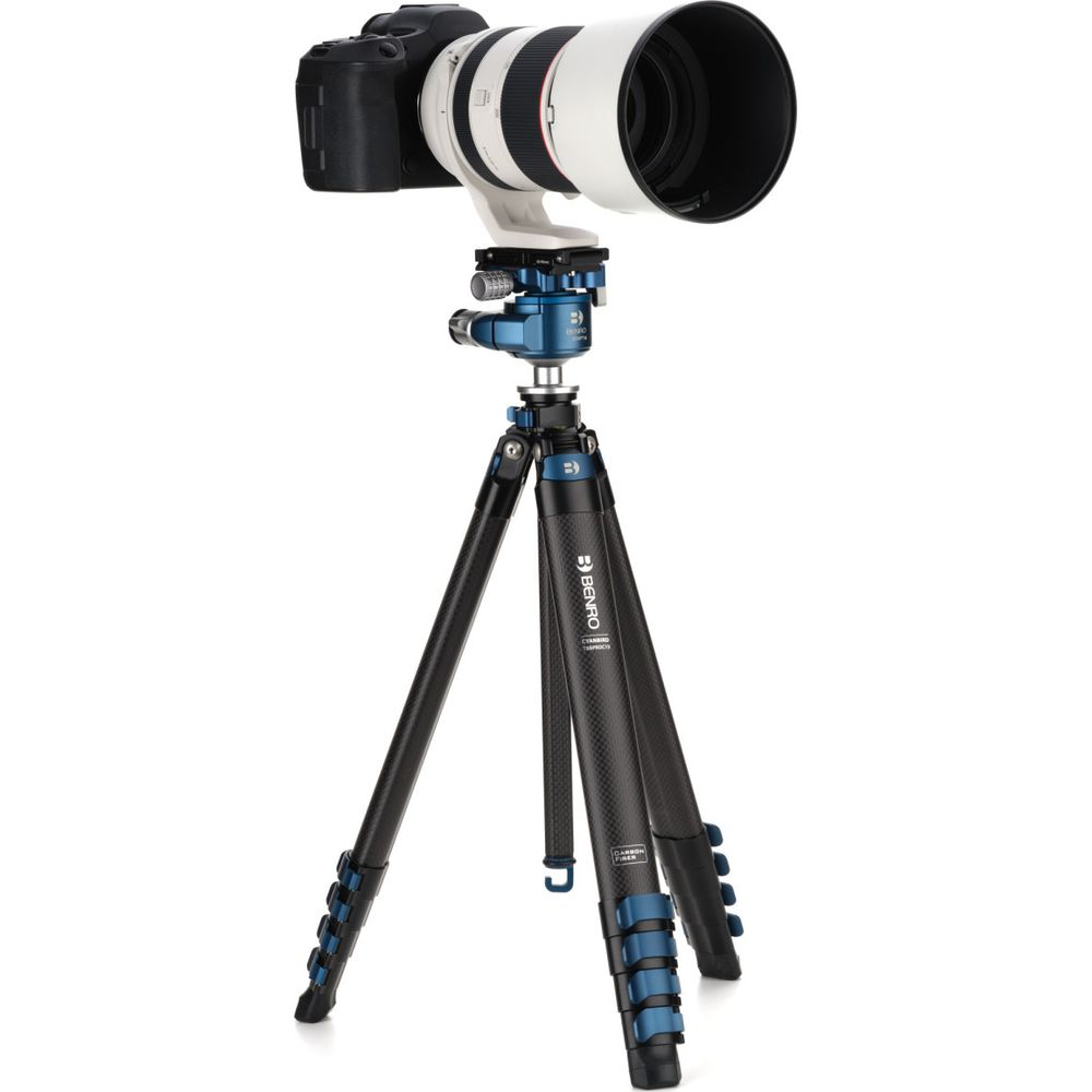 Un appareil photo reflex numérique noir avec un téléobjectif blanc sur un trépied Benro bleu et noir.