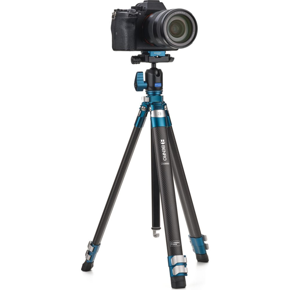 Un appareil photo noir est monté sur un trépied bleu en fibre de carbone.