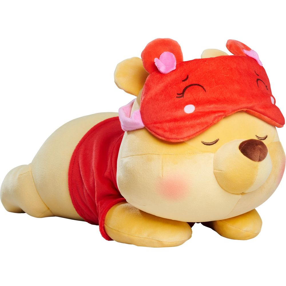 Peluche Winnie the Pooh giallo con maglia rossa e maschera da notte su sfondo bianco.