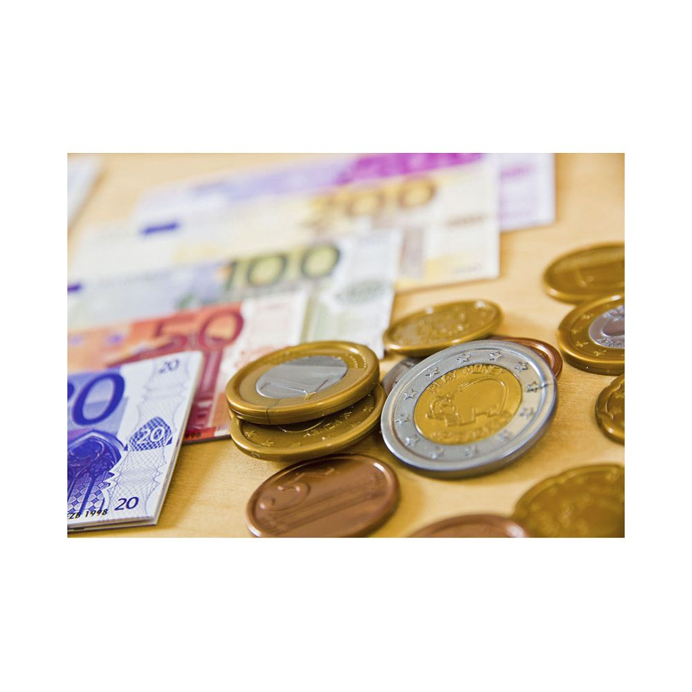 Banconote e monete in euro sparse su un tavolo di legno.