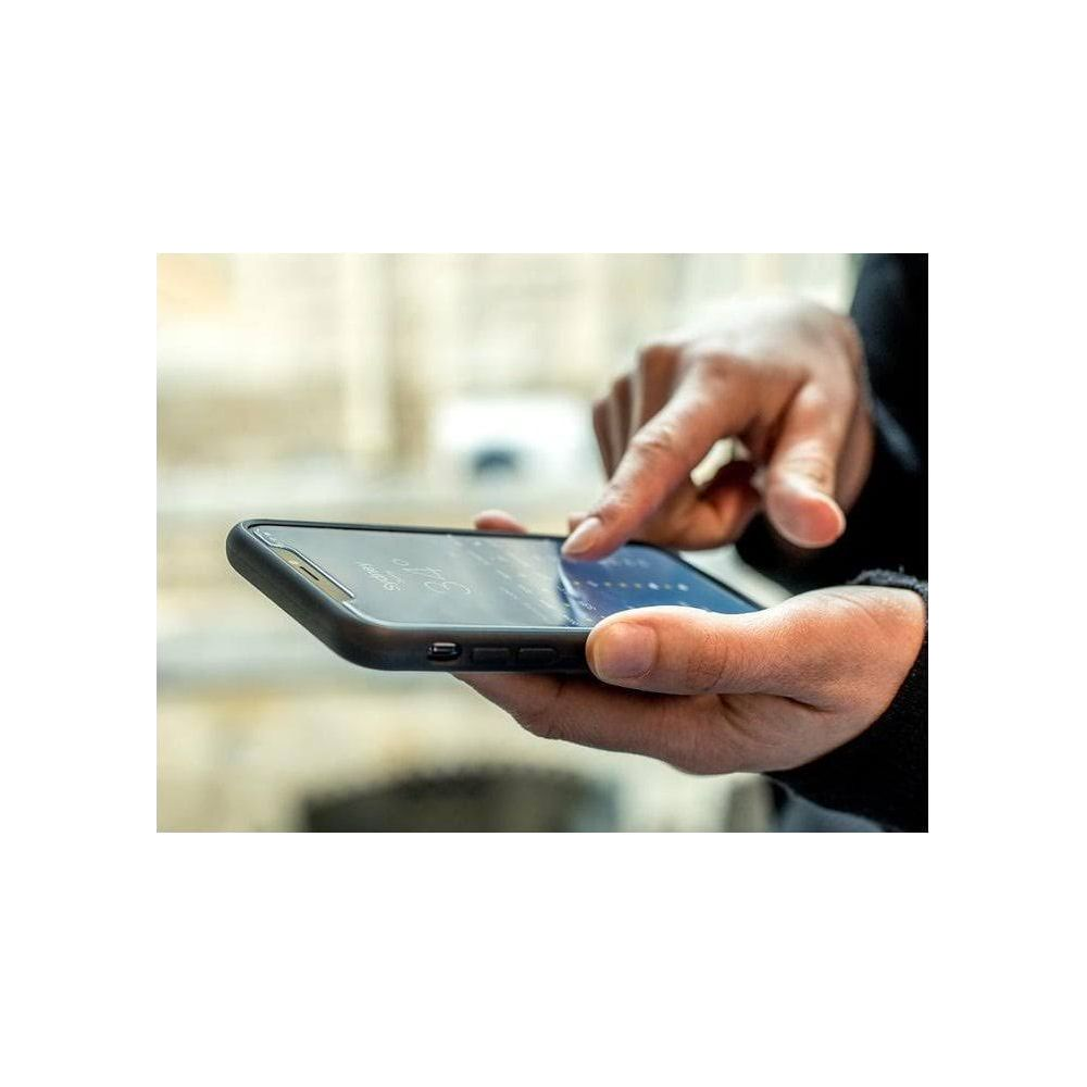 Hände halten ein Smartphone mit Finanzdaten, Finger tippt auf den Bildschirm.