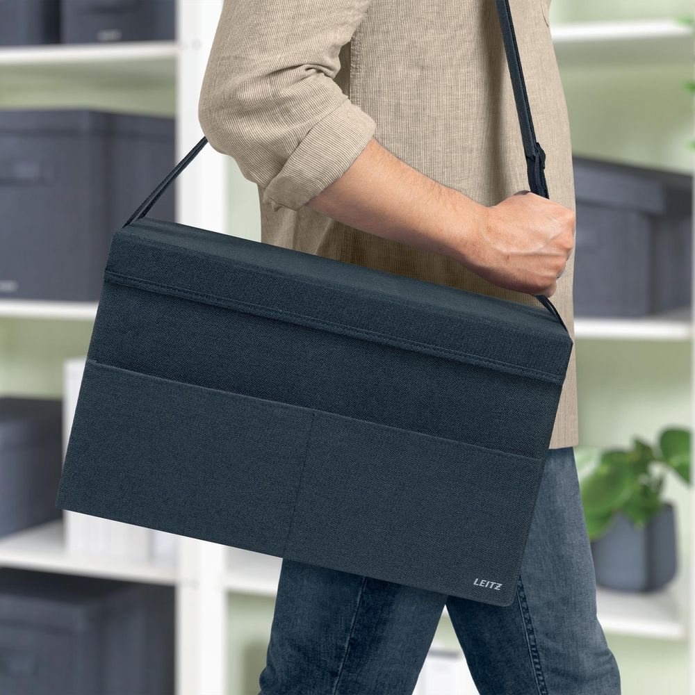 Dunkelblauer Aufbewahrungsbehälter mit Taschen, getragen über der Schulter.