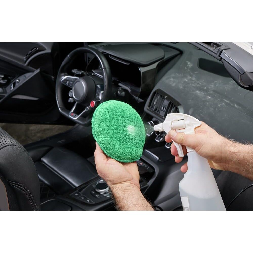 Homme nettoyant l'intérieur de voiture avec vaporisateur et chiffon.