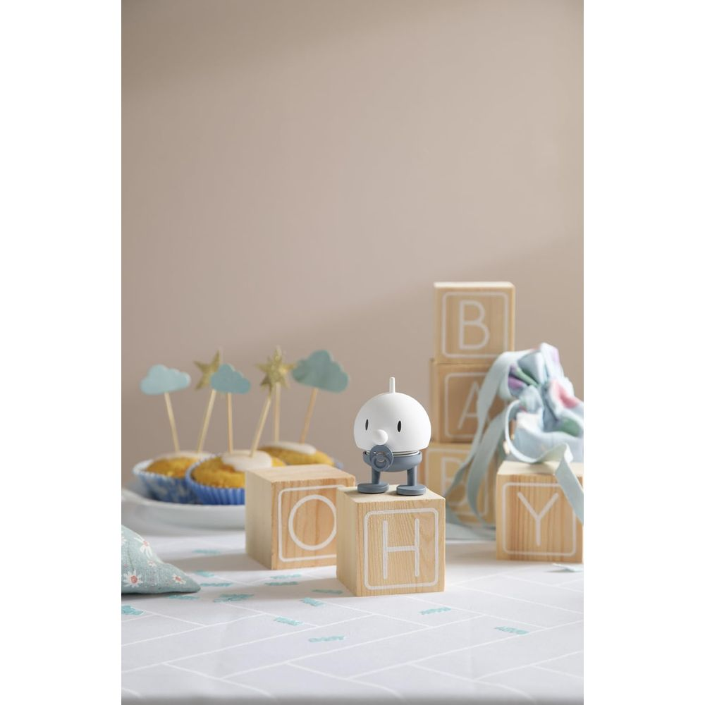 Un set di decorazioni a tema bebè con tortine, blocchi di legno e una figura.