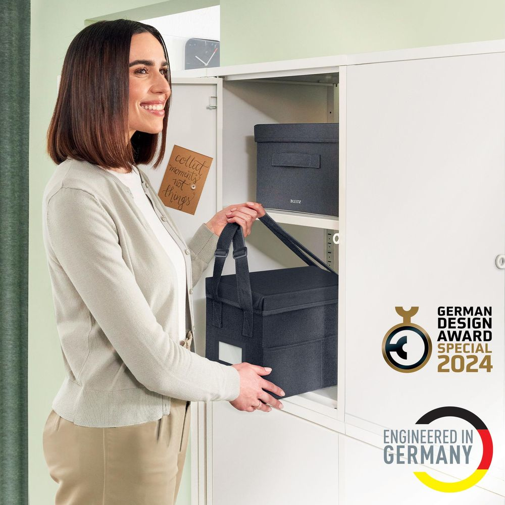 Frau holt dunkelgraue Aufbewahrungsbox aus weißem Schrank mit Notiz.
