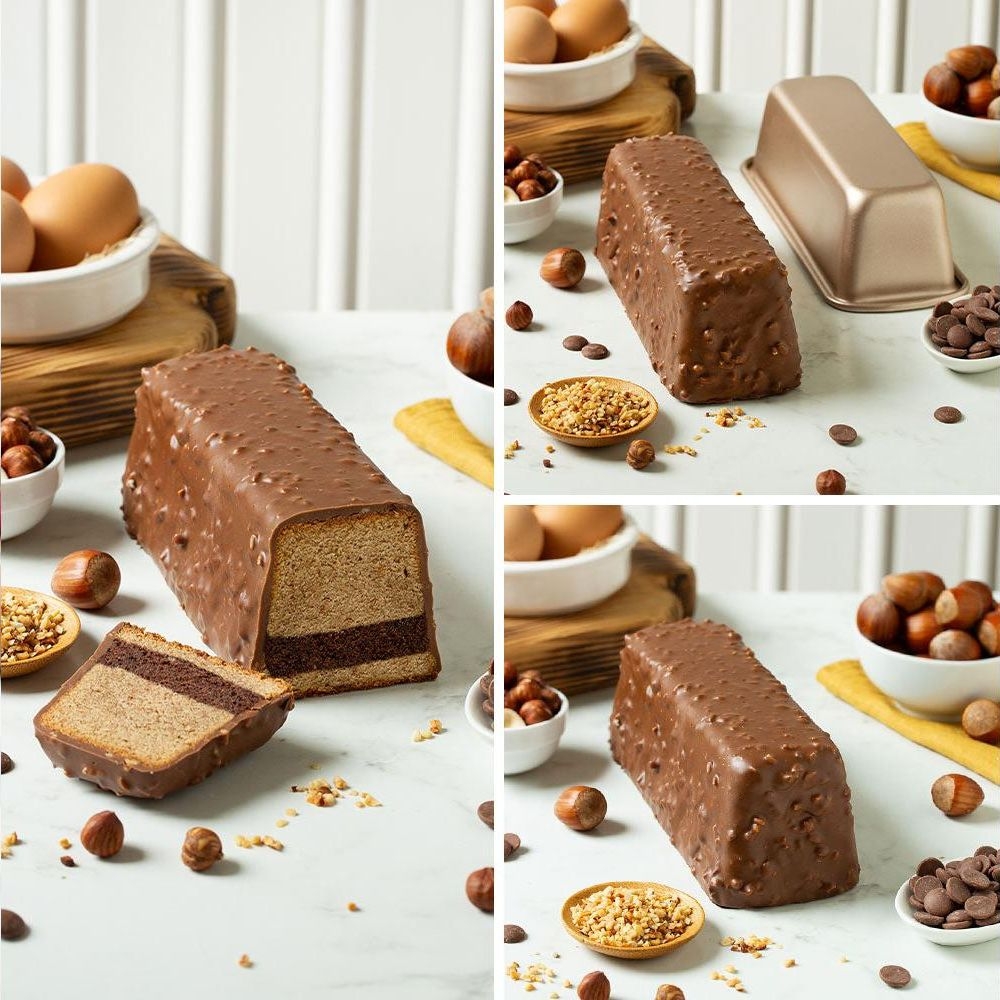 Ein schokoladenüberzogener Kuchen mit einem herausgeschnittenen Stück, das zwei Schichten zeigt, umgeben von Haselnüssen und Schokoladenstückchen.
