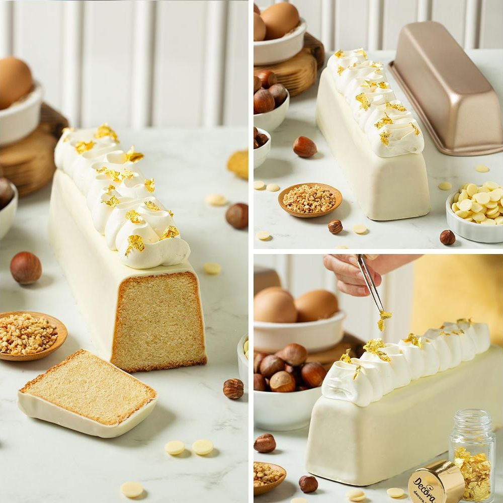 Ein rechteckiger Kuchen mit weißem Fondant, gekrönt mit Sahnetuffs und Blattgold.