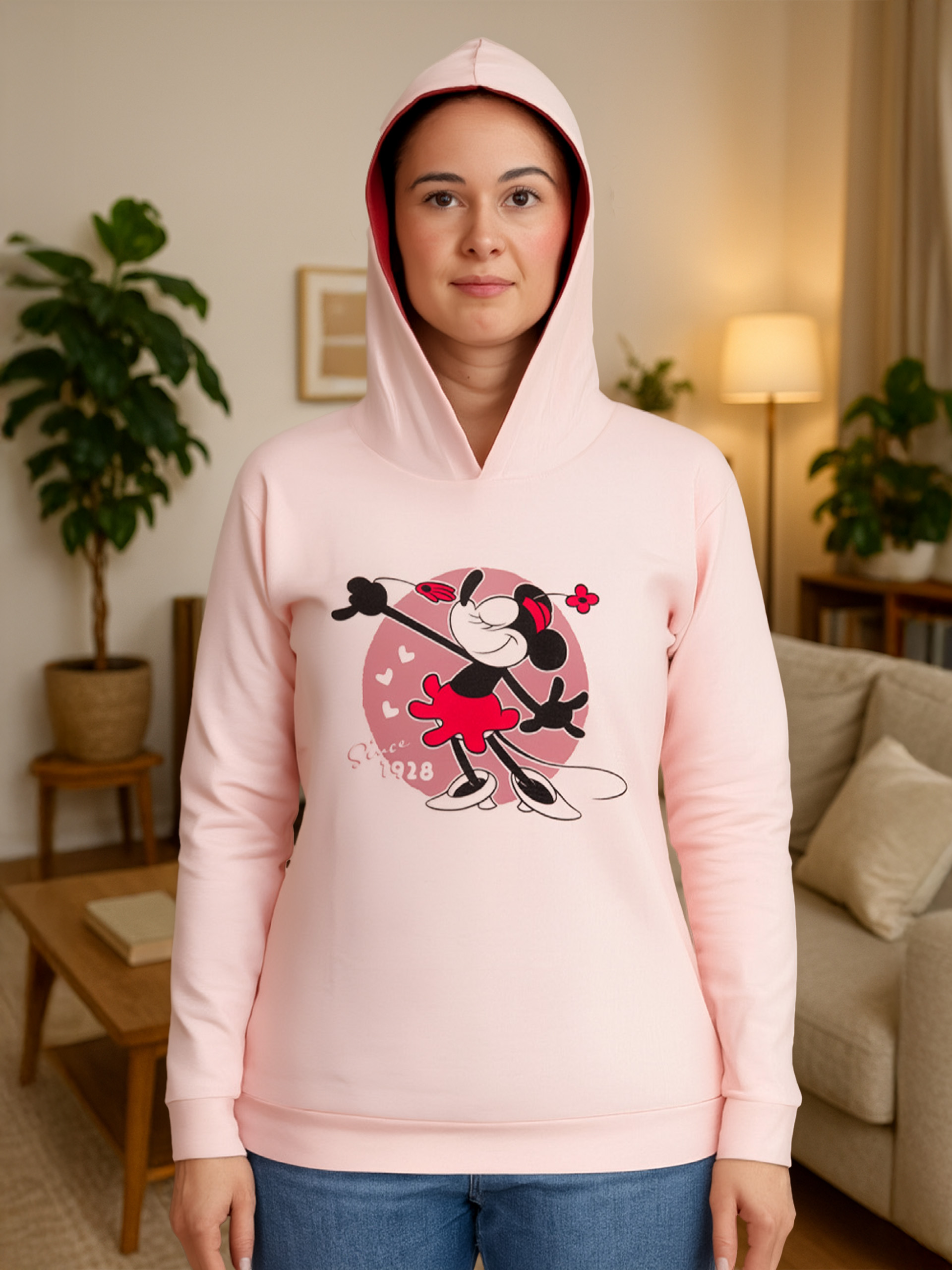 Eine Frau trägt einen rosa Kapuzenpullover mit Minnie Maus Aufdruck.