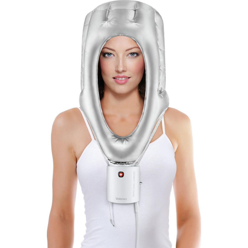 Frau mit silbernem aufblasbarem Haartrockner-Helm und weißem Top.