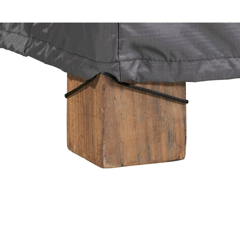 Graue Abdeckung über einem Holzwürfel, mit schwarzer Kordel gesichert.
