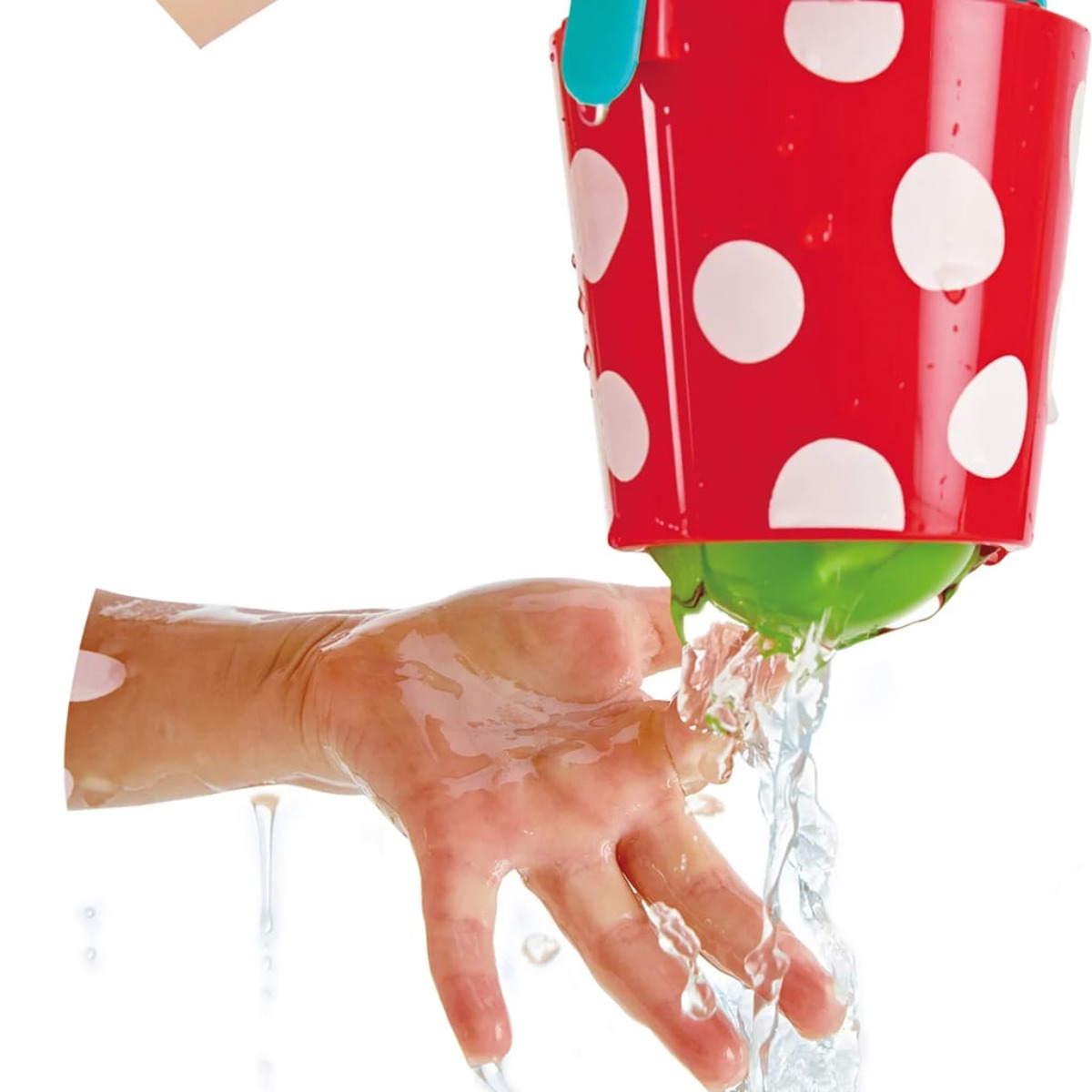 Seau rouge à pois blancs, eau coulant sur une main.