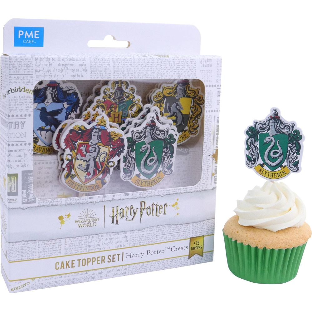 Harry Potter Tortenaufsätze in einer Box und ein Slytherin-Aufsatz auf einem Cupcake.