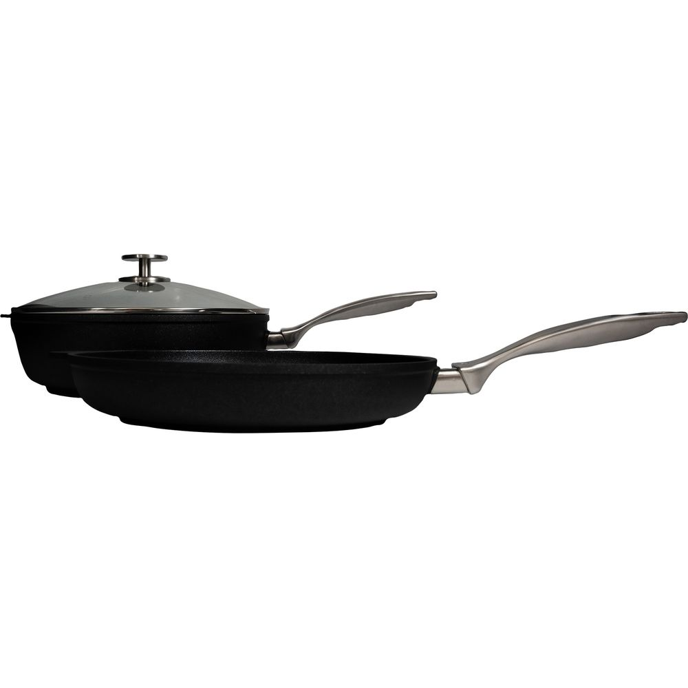 Une casserole noire avec un couvercle en verre transparent et une poêle à frire noire avec une poignée argentée sont présentées sur un fond blanc.