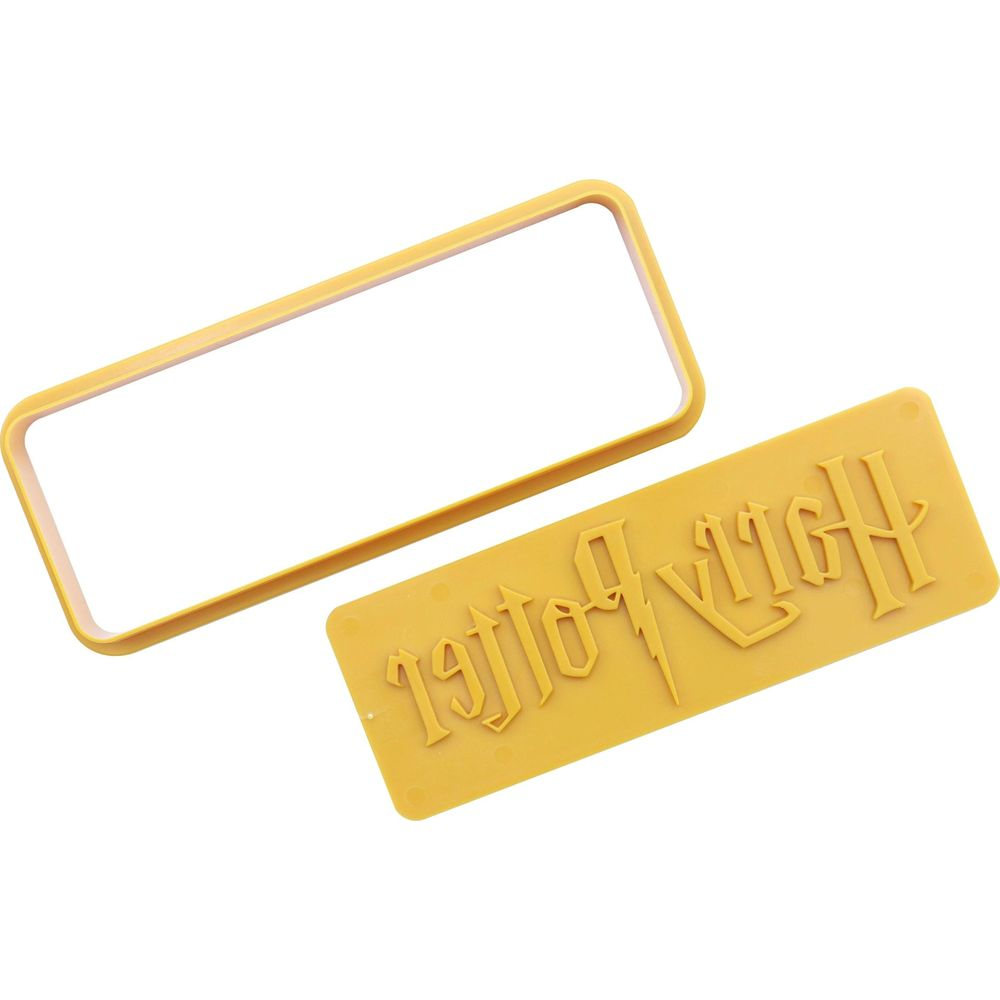 Un tampon logo jaune Harry Potter et un emporte-pièce rectangulaire sur fond blanc.