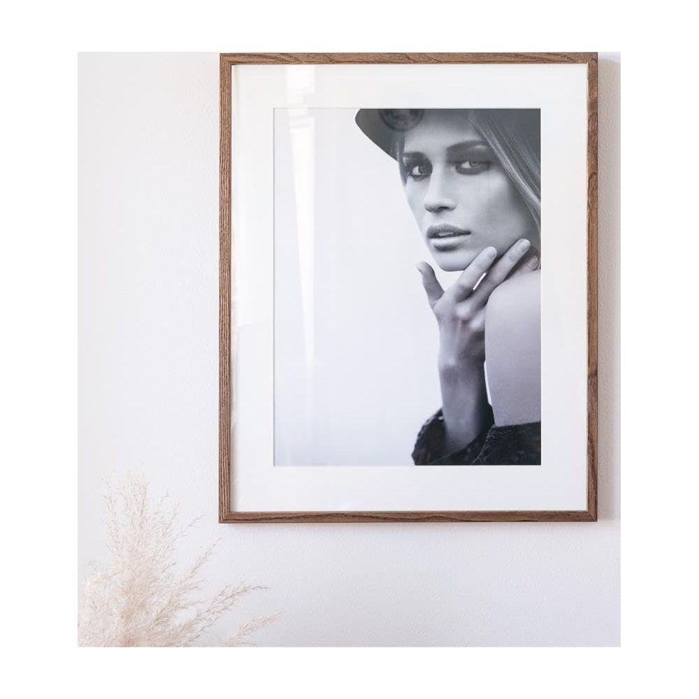 Photo noir et blanc d'une femme portant un chapeau, touchant son menton.