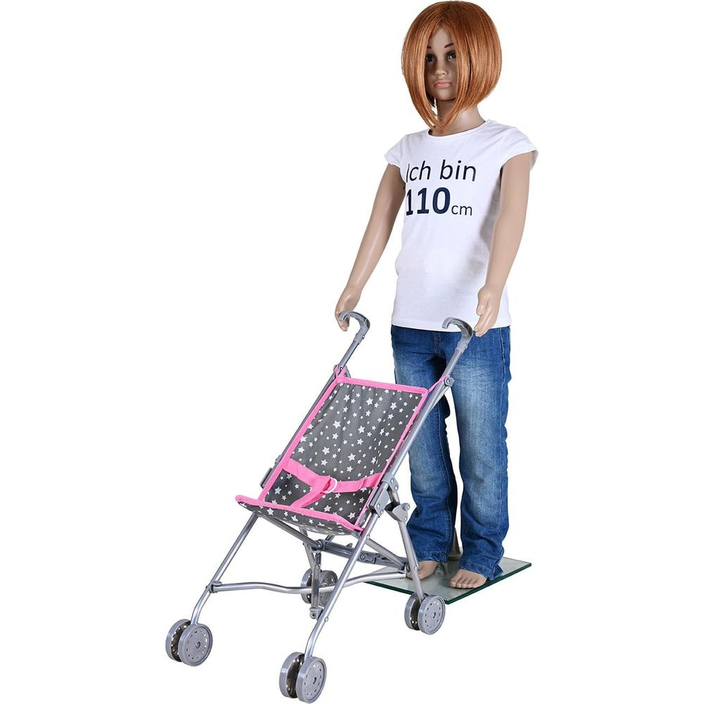 Schaufensterpuppe in Jeans und T-Shirt schiebt einen Sternen-Kinderwagen.