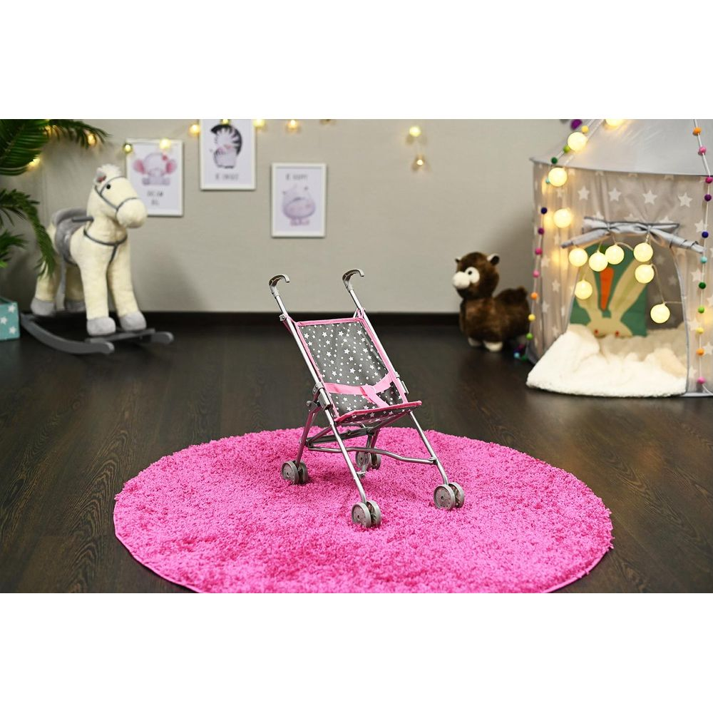 Ein Puppenwagen steht auf einem pinken Teppich. Im Hintergrund ein Schaukelpferd.